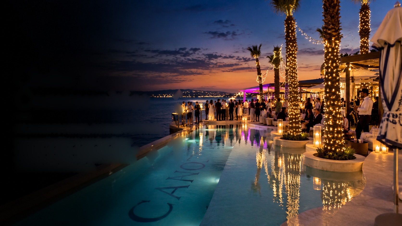 Club members gathered at a candlelit poolside beach club at sunset, palm trees wrapped in lights